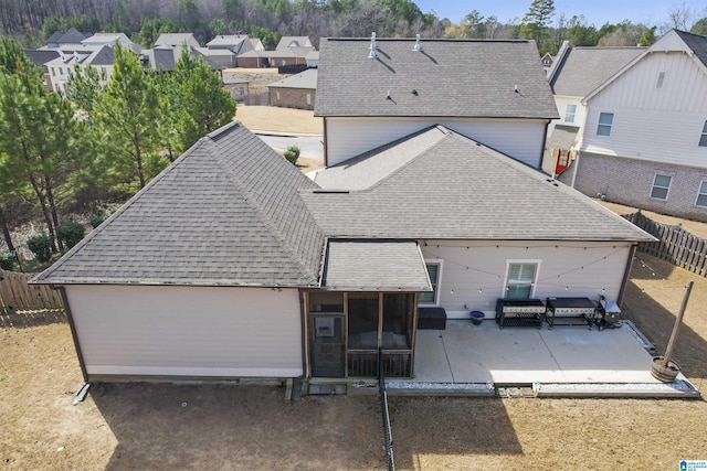 rear view of house featuring a shingled roof, a patio area, a fenced backyard, and a residential view