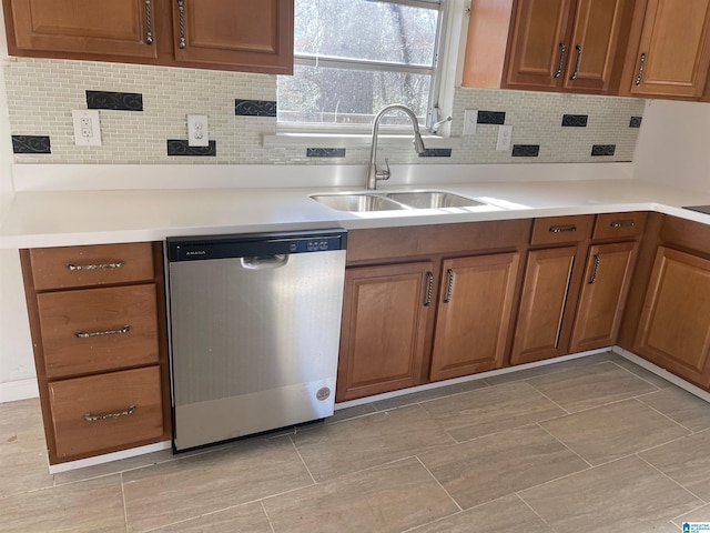 kitchen featuring a sink, light countertops, dishwasher, tasteful backsplash, and brown cabinetry