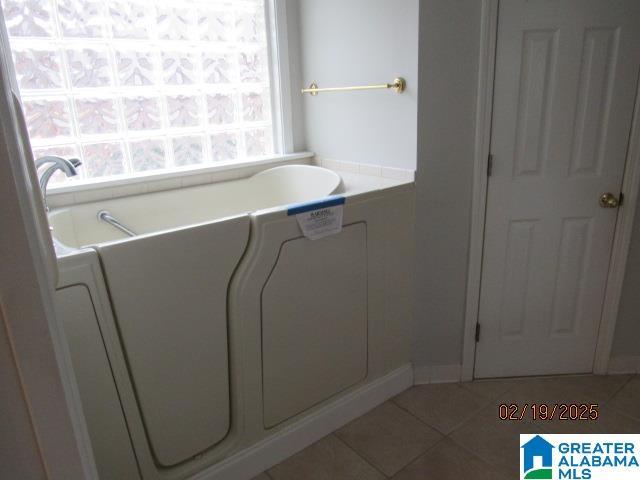 full bath featuring tile patterned flooring and a bath