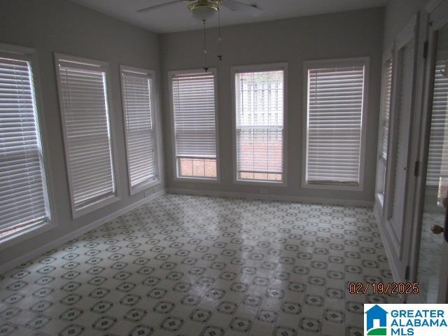 unfurnished sunroom with a ceiling fan