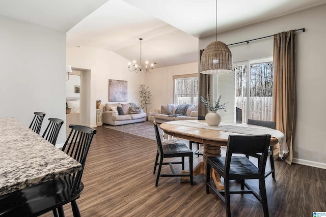 dining area featuring dark wood-style floors, a notable chandelier, vaulted ceiling, and baseboards