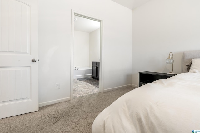 bedroom with carpet floors, baseboards, and ensuite bathroom