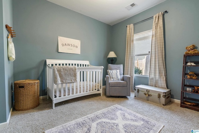 carpeted bedroom with a nursery area, visible vents, and baseboards