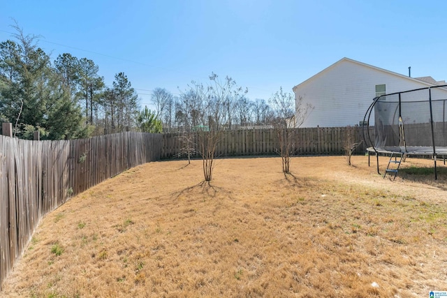 view of yard featuring a fenced backyard and a trampoline