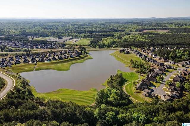 drone / aerial view featuring a water view, a wooded view, and a residential view