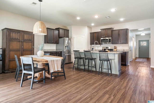 kitchen featuring appliances with stainless steel finishes, visible vents, dark brown cabinets, and dark wood-style floors