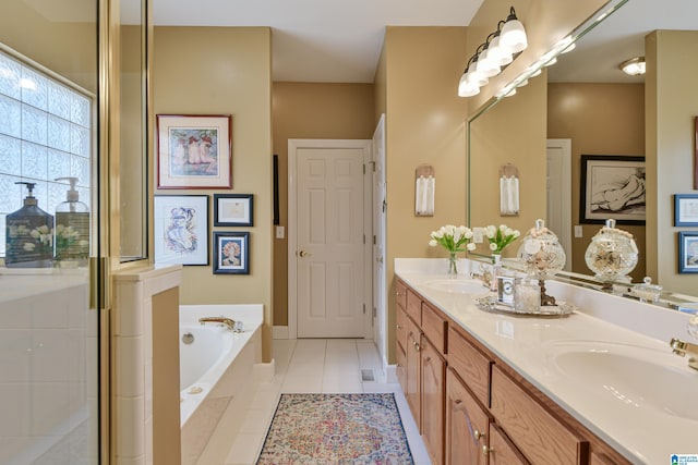 bathroom with tile patterned flooring, double vanity, a sink, and a bath