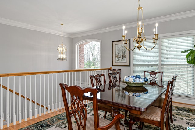 dining space with crown molding, wood finished floors, and a notable chandelier