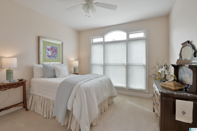 bedroom with light carpet and a ceiling fan