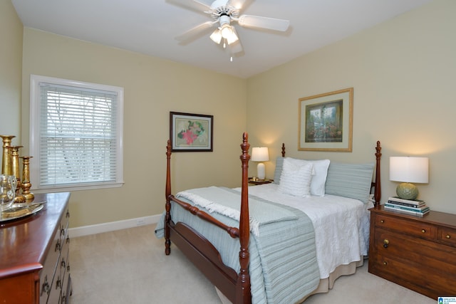 bedroom with light colored carpet, ceiling fan, and baseboards