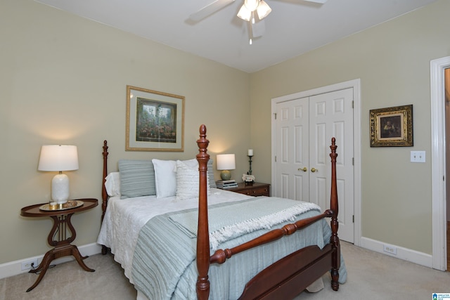 bedroom with a closet, light carpet, ceiling fan, and baseboards