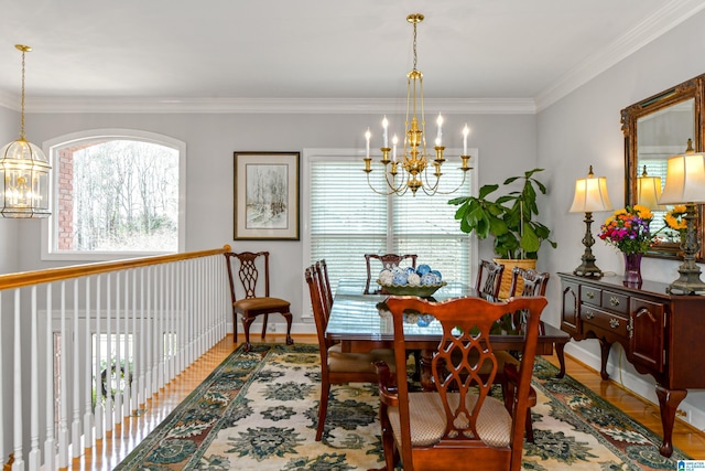 dining room featuring crown molding, baseboards, wood finished floors, and a notable chandelier