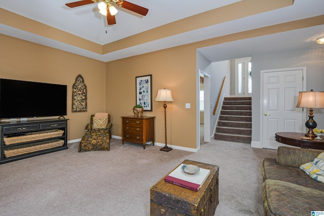 living area with carpet floors, ceiling fan, stairway, and baseboards