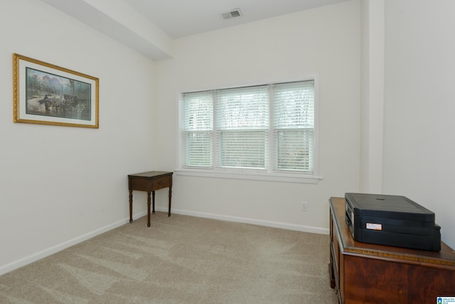 unfurnished room with baseboards, visible vents, and light colored carpet