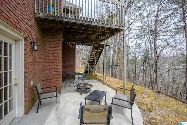 view of patio with a fire pit and stairs