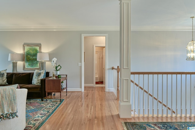 interior space with baseboards, ornamental molding, wood finished floors, and a notable chandelier