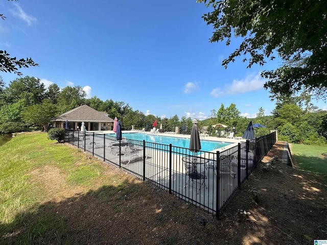 pool with a patio area, fence, and a lawn