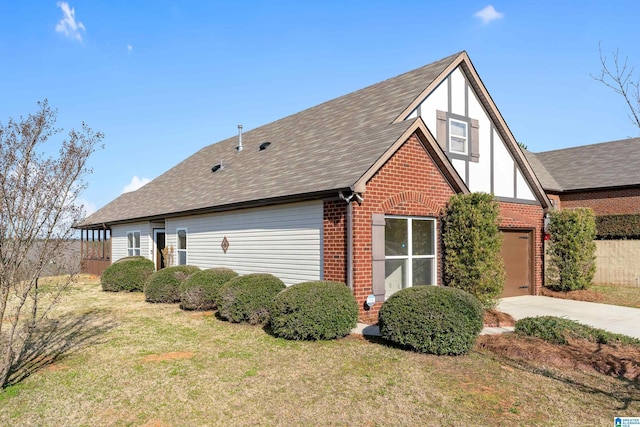 view of side of home with driveway, a garage, a lawn, and brick siding