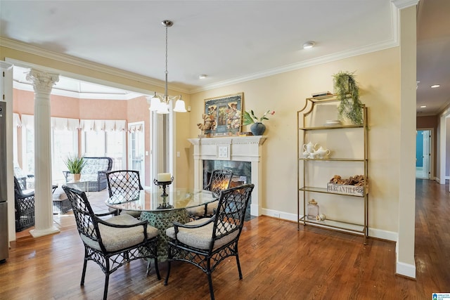 dining space featuring decorative columns, ornamental molding, and wood finished floors