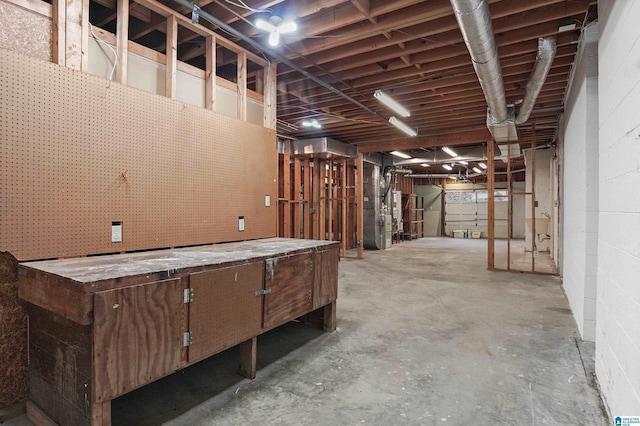 misc room with concrete block wall, heating unit, and concrete floors