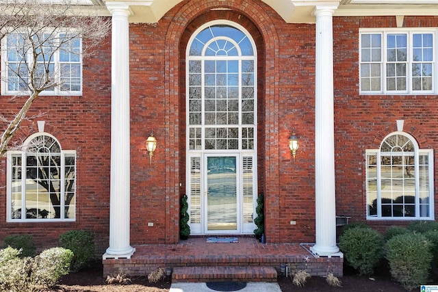 view of exterior entry with brick siding