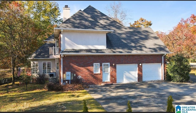 view of front facade featuring a garage, brick siding, fence, and a chimney