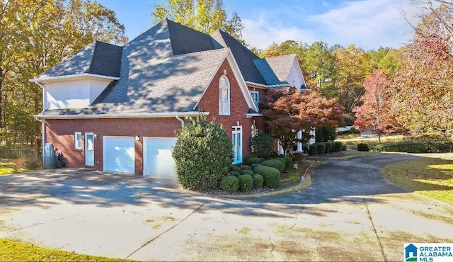 view of side of home with a garage, concrete driveway, brick siding, and a shingled roof