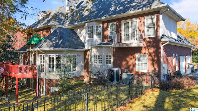 rear view of house featuring fence private yard, central AC unit, and brick siding