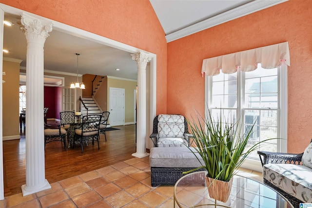 living area with decorative columns, a textured wall, stairway, crown molding, and a notable chandelier