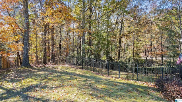 view of yard featuring fence and a forest view