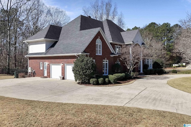 view of front of house featuring concrete driveway, brick siding, and a shingled roof