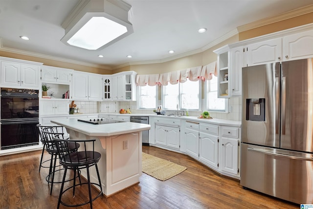 kitchen featuring white cabinets, a breakfast bar, a center island, black appliances, and open shelves