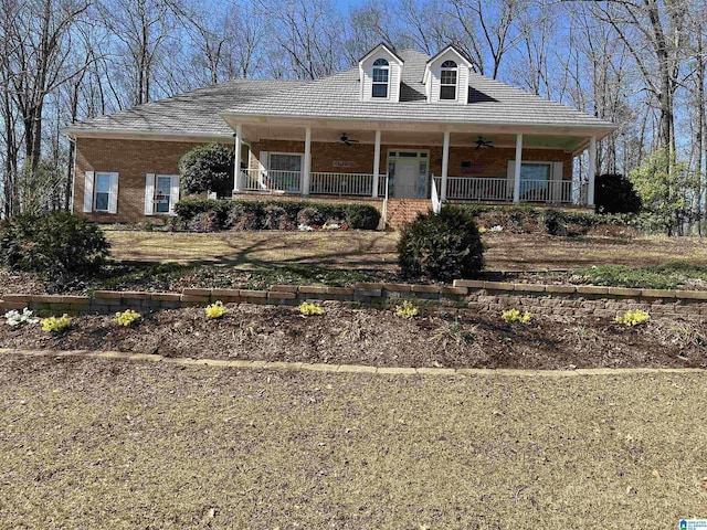 view of front of property featuring covered porch, ceiling fan, and brick siding