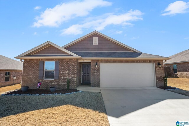 view of front of home with an attached garage, a front lawn, concrete driveway, and brick siding