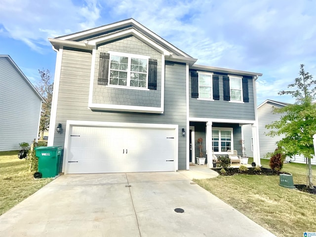 view of front of property featuring driveway, covered porch, an attached garage, and a front yard