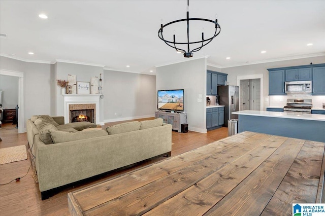 living room with light wood-type flooring, a warm lit fireplace, baseboards, and recessed lighting