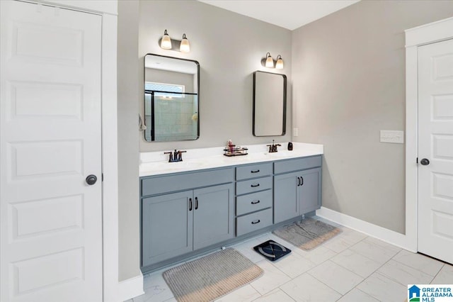 bathroom featuring double vanity, marble finish floor, baseboards, and a sink