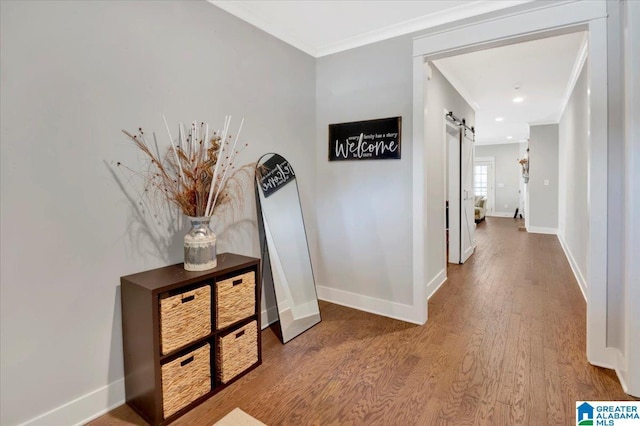 corridor with wood finished floors, baseboards, and a barn door