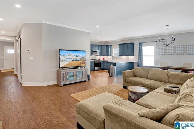 living area with light wood-style flooring, baseboards, crown molding, and a barn door