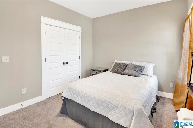 carpeted bedroom with a closet and baseboards