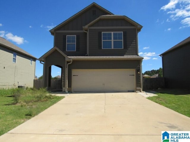 view of front of house with an attached garage, driveway, fence, and board and batten siding