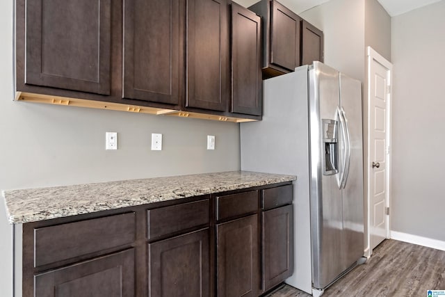 kitchen with baseboards, dark brown cabinets, wood finished floors, and stainless steel fridge with ice dispenser