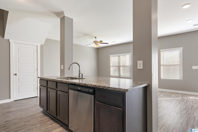 kitchen featuring light stone counters, a sink, baseboards, stainless steel dishwasher, and light wood-type flooring