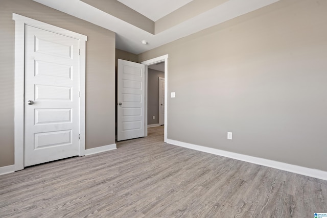 unfurnished bedroom featuring wood finished floors and baseboards