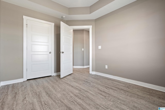 unfurnished bedroom with light wood-style flooring and baseboards