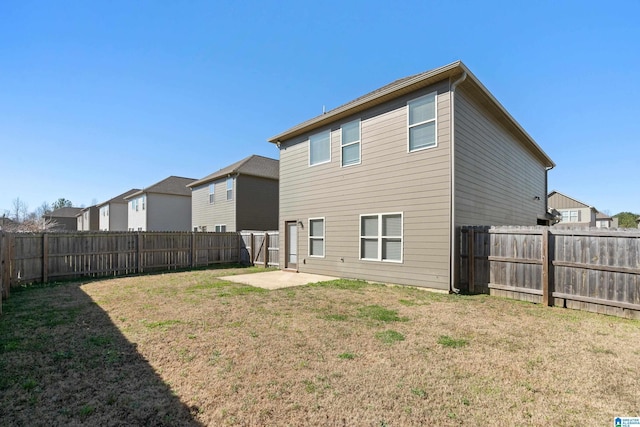 rear view of property featuring a patio area, a fenced backyard, and a yard