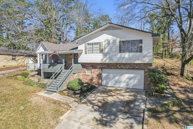 tri-level home with brick siding, covered porch, concrete driveway, an attached garage, and stairs