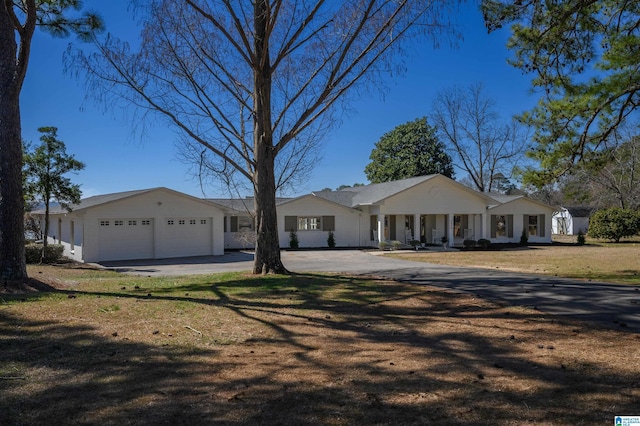 view of front facade featuring driveway, a garage, and a front lawn