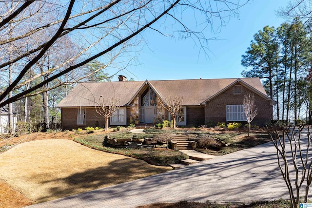 view of front of house with brick siding and a chimney