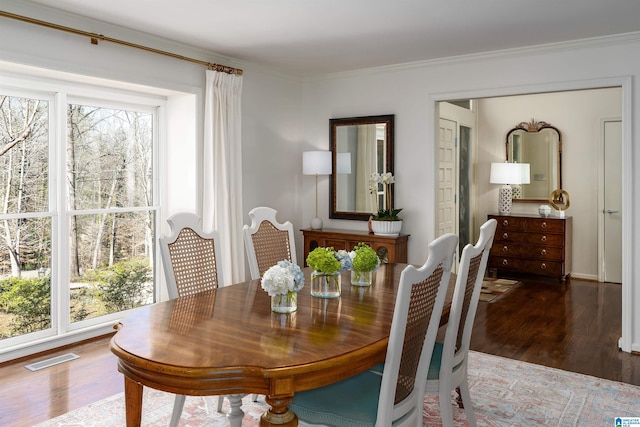 dining space with wood finished floors, visible vents, and a healthy amount of sunlight